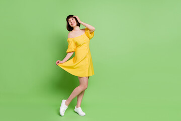 Fototapeta na wymiar Full length body size view of attractive cheerful girl dancing having fun free time isolated over green color background
