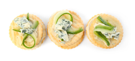 Delicious crackers with cheese and cucumber on white background, top view