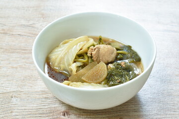 boiled mixed vegetable with chicken in black soybean soup in bowl on table