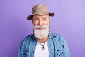 Photo of aged man happy positive smile wear hat headwear tourist trip isolated over purple color background