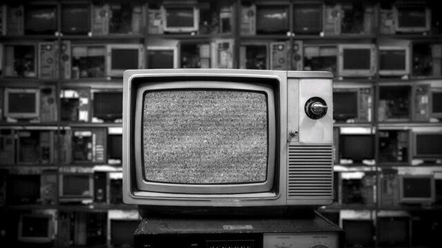 Television Static Noise Zoom In Retro Technology Background. Vintage television display static noise interference with many broken monitors in the background. Zoom in