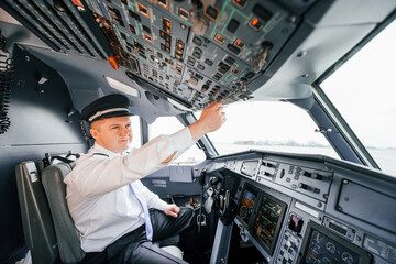 Control of the flight. Pilot on the work in the passenger airplane. Preparing for takeoff