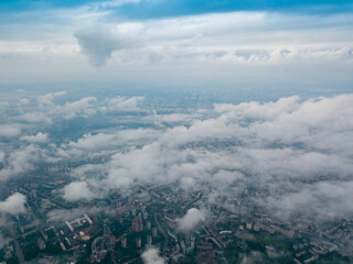 High flight above the clouds in Kiev. Spring morning. Aerial high view.