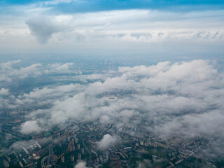 High flight above the clouds in Kiev. Spring morning. Aerial high view.