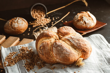 Bread on dark background. Fresh crispy baking, old style. - obrazy, fototapety, plakaty