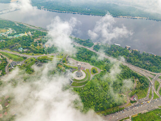 Fototapeta na wymiar Motherland monument in Kiev between the clouds. Aerial drone view.