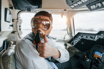 In oxygen mask. Pilot on the work in the passenger airplane. Preparing for takeoff - obrazy, fototapety, plakaty