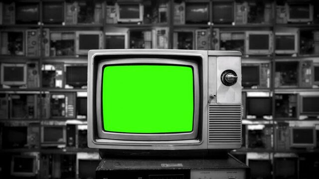 Retro Technology Green Screen Television Zoom In TV. Vintage television display a green screen, for replacement, with many broken monitors in the background. Zoom in