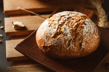 Bread on dark background. Fresh crispy baking, old style.