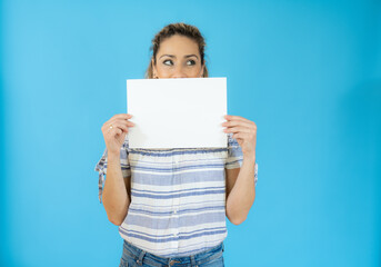 Funny woman holding white banner isolated over blue background.