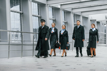 Obraz premium Aircraft crew in work uniform is together outdoors in the airport