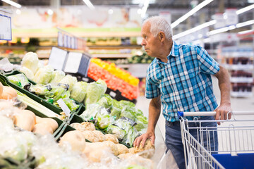 old age man choosing turnipes in supermarket