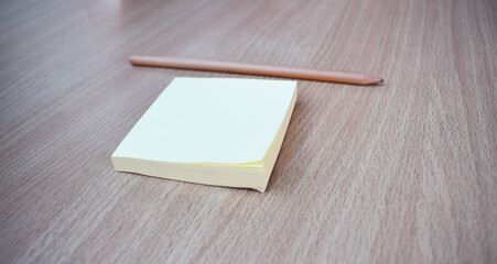 Top view of post-it and pencil on wooden table.