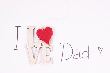 Fathers day composition.I love Dad text with red felt heart on white background.