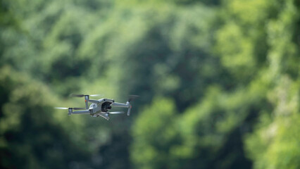 Drone hovering in sunny day in nature background