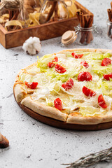 Top view on caesar pizza with iceberg salad and tomatoes