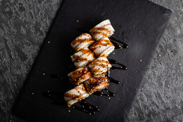 Set of fresh tasty sushi rolls on a dark background.