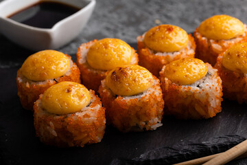 Fresh sushi roll set. Sushi rolls california with cheese. Sushi on black background, chopsticks, wasabi, soy.