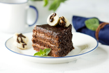 Delicious fresh chocolate cake with banana slices and mint