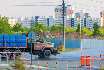 A special machine irrigates the road in the city, removing garbage and dampening the asphalt from the heat.