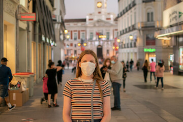 Prevention of coronavirus outbreak in 2020. Portrait of young European woman wearing a mask in the city street. Medical mask. FFP2 mask Prevent pollution and disease concept.