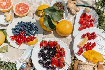 Top view picnic blanket full of variety of fruits and spices.