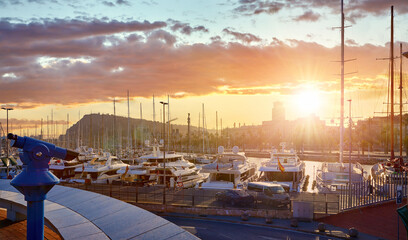 Barcelona Spain. Landing bay at sunset with luxury chic yachts and boats. Cityscape in ray sun.