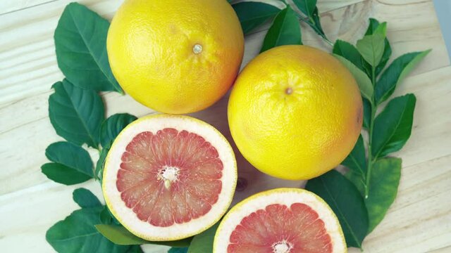 Fresh Grapefruit with leaves on Wooden background, Top view Rotate Grapefruit or Pomelo on Wooden background, 4k resolution.