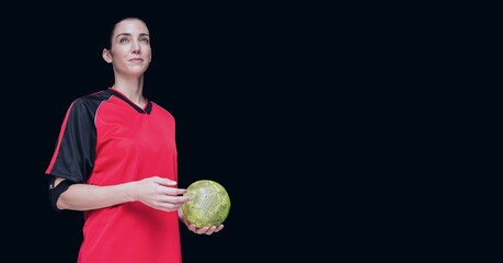 Composition of caucasian female handball player holding ball with copy space on black background