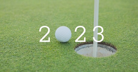 Composition of 2023 number with golf ball by hole on golf course