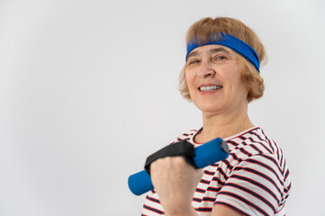 Happy old woman doing fitness exercises with dumbbells on a white background. Elderly lady doing fitness to maintain health.