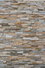 Vertical shot of modern stone wall. Texture wallpaper background.