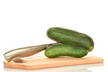 One ripe green custom cucumber with a metal knife on a wooden board, close-up, isolated on white.