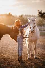 Obraz premium Young woman farmer combing a horse at the ranch.