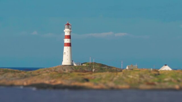 Kristiansand lighthouse Oks&oslash;y or fyr Oksoy standing on the island in the sea greeting sailors and travelers. Small houses also stand on the island - home to the lighthouse keeper.