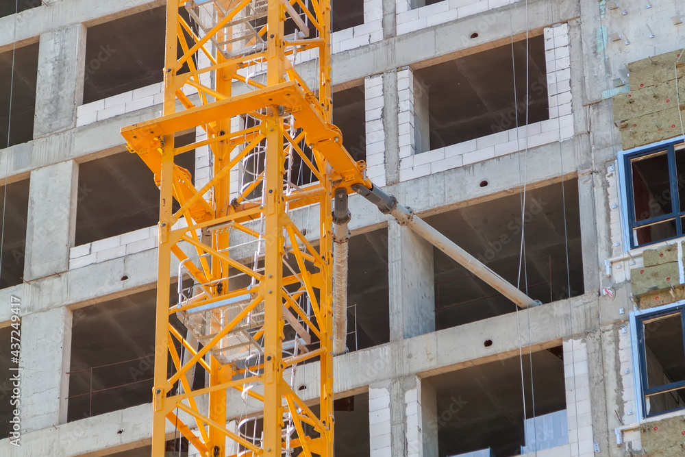 Poster close up view of frame part of metallic crane machinery attachment at windows of new residential bui