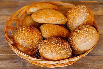 Buns for burgers and sandwiches, sesame bun, buns. Fresh burger bread with sesame seeds on a wooden background. Delicious hamburger buns.