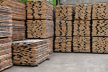 Unedged board of soft wood stacked in the open air. Selective focus.