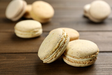 Delicious macarons on wooden table, closeup. Sweet dessert