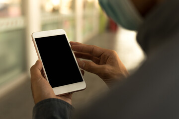 Men's hands use a smartphone for online shopping, social networking, or remote work. Close up image.