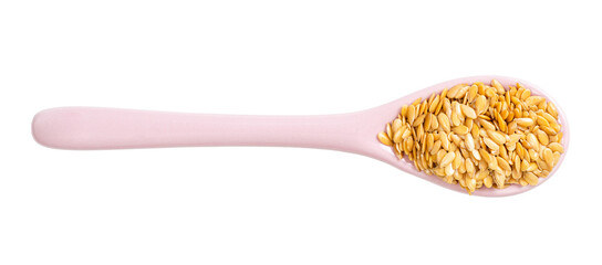ceramic spoon with golden flax seeds isolated
