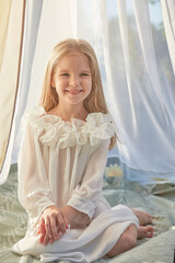 Fototapeta na wymiar Little girl in white chiffon tent