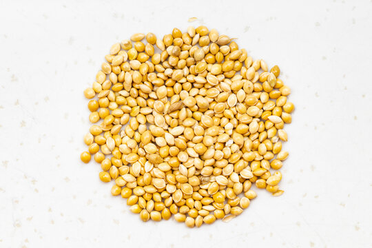 pile of unpolished yellow proso millet on gray