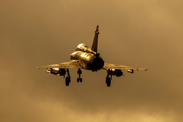 Avión de combate Mirage 2000 aterrizando al anochecer