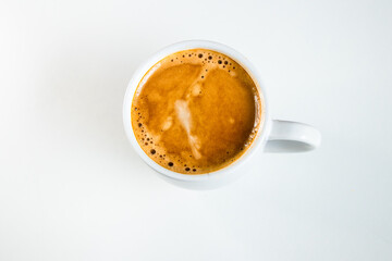 A close up of a white coffee cup with coffee on a white background.