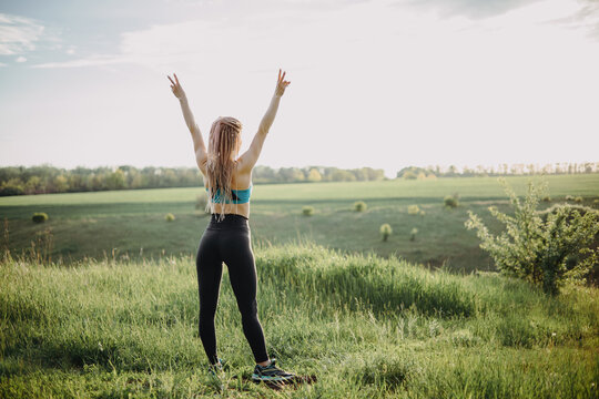 Sporty fit woman raising arms express positivity