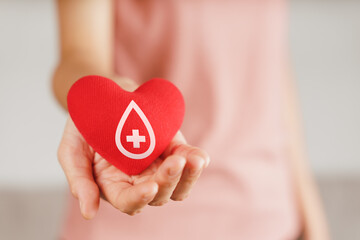 Woman hands holding red heart with blood donor sign. healthcare, medicine and blood donation...
