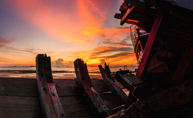Ship capsized Old fishing ship at sunset sky for landscape nature wallpaper back ground .