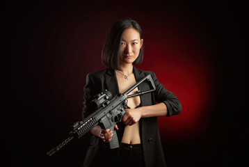 asian woman in a jacket with an automatic rifle in her hands mafia fighter - obrazy, fototapety, plakaty