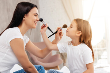 Happy family doing makeup together using brushes